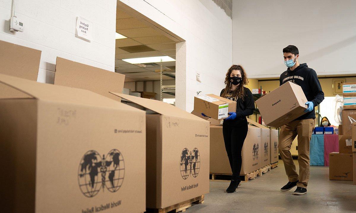 Two people walking with boxes